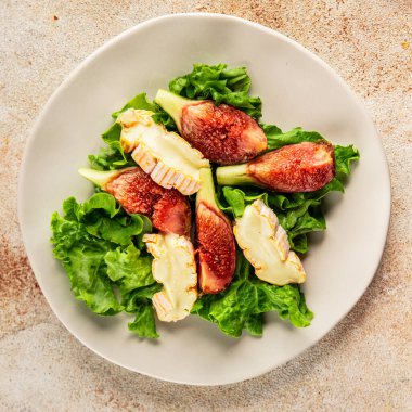 Salata inciri, yumuşak peynir, yeşil yaprak marul lezzetli aperatif lezzetli lezzetli gurme yemek arkaplan masa üzerinde rustik gıda üst görünüm fotokopi alanı keto ve paleo diyet vejetaryen gıda