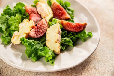 Salata inciri, yumuşak peynir, yeşil yaprak marul lezzetli aperatif lezzetli lezzetli gurme yemek arkaplan masa üzerinde rustik gıda üst görünüm fotokopi alanı keto ve paleo diyet vejetaryen gıda