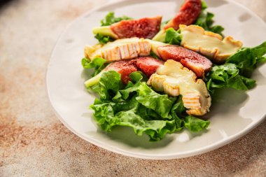 Salata inciri, yumuşak peynir, yeşil yaprak marul lezzetli aperatif lezzetli lezzetli gurme yemek arkaplan masa üzerinde rustik gıda üst görünüm fotokopi alanı keto ve paleo diyet vejetaryen gıda