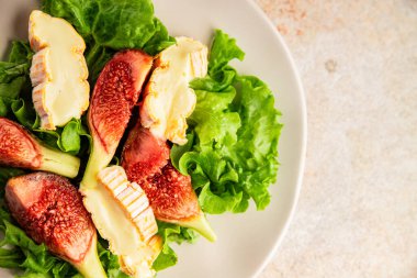 Salata inciri, yumuşak peynir, yeşil yaprak marul lezzetli aperatif lezzetli lezzetli gurme yemek arkaplan masa üzerinde rustik gıda üst görünüm fotokopi alanı keto ve paleo diyet vejetaryen gıda