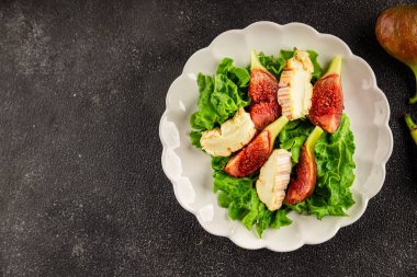 Salata inciri, yumuşak peynir, yeşil yaprak marul lezzetli aperatif lezzetli lezzetli gurme yemek arkaplan masa üzerinde rustik gıda üst görünüm fotokopi alanı keto ve paleo diyet vejetaryen gıda