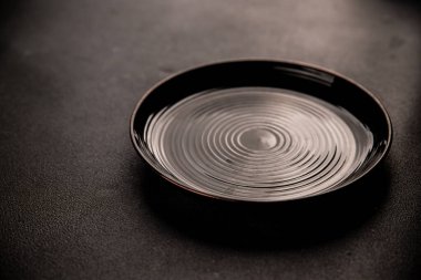 Tabak siyah sofra takımı boş yemek takımı tabakları servis etmeye hazır sofra arkasında yemek seramik tabağı servis etmeye hazır.