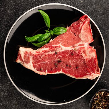 Çiğ biftek T-bone taze et prim biftek aperatif taze lezzetli gurme yemek arka planı masa rustik gıda üst görünüm fotokopi alanı