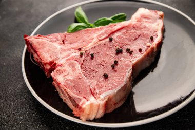 Çiğ biftek T-bone taze et prim biftek aperatif taze lezzetli gurme yemek arka planı masa rustik gıda üst görünüm fotokopi alanı
