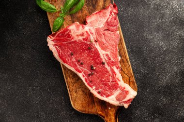Çiğ biftek T-bone taze et prim biftek aperatif taze lezzetli gurme yemek arka planı masa rustik gıda üst görünüm fotokopi alanı