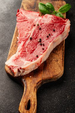 Çiğ biftek T-bone taze et prim biftek aperatif taze lezzetli gurme yemek arka planı masa rustik gıda üst görünüm fotokopi alanı