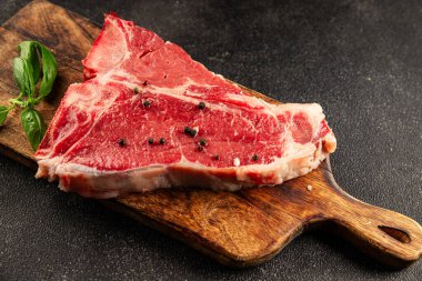 Çiğ biftek T-bone taze et prim biftek aperatif taze lezzetli gurme yemek arka planı masa rustik gıda üst görünüm fotokopi alanı