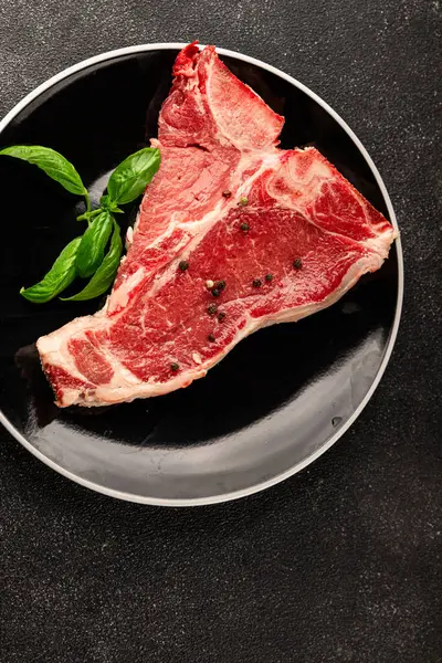 Çiğ biftek T-bone taze et prim biftek aperatif taze lezzetli gurme yemek arka planı masa rustik gıda üst görünüm fotokopi alanı