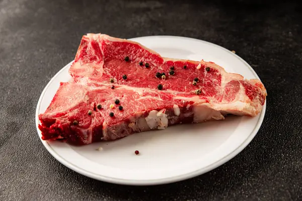 Çiğ biftek T-bone taze et prim biftek aperatif taze lezzetli gurme yemek arka planı masa rustik gıda üst görünüm fotokopi alanı