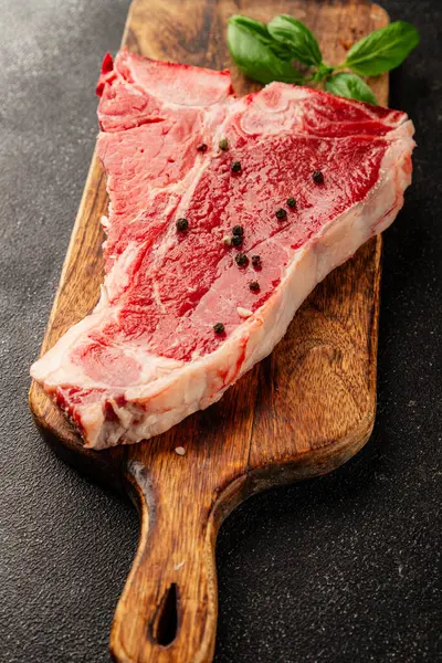 Çiğ biftek T-bone taze et prim biftek aperatif taze lezzetli gurme yemek arka planı masa rustik gıda üst görünüm fotokopi alanı