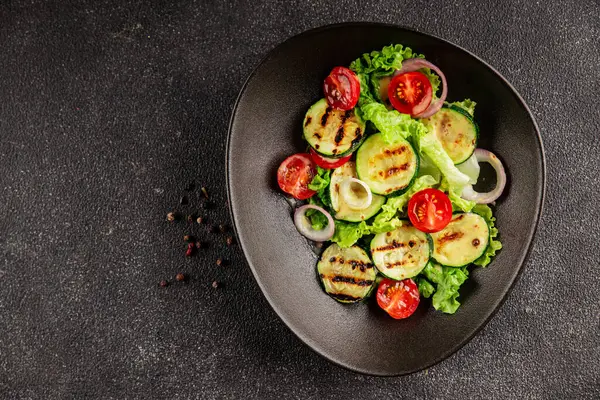 Salata ızgara kabak, domates, marul, lezzetli aperatif lezzetli lezzetli gurme yemek arkaplan masa üzerinde rustik gıda üst görünüm fotokopi alanı keto ve paleo diyet vegan ve vejetaryen gıda
