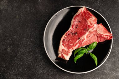 Çiğ biftek T-bone taze et prim biftek aperatif taze lezzetli gurme yemek arka planı masa rustik gıda üst görünüm fotokopi alanı