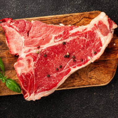 Çiğ biftek T-bone taze et prim biftek aperatif taze lezzetli gurme yemek arka planı masa rustik gıda üst görünüm fotokopi alanı