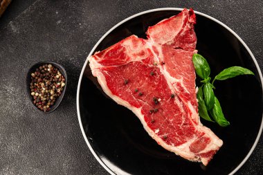 Çiğ biftek T-bone taze et prim biftek aperatif taze lezzetli gurme yemek arka planı masa rustik gıda üst görünüm fotokopi alanı