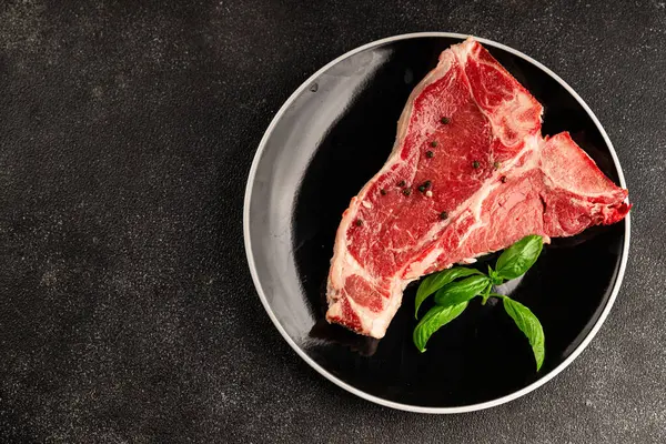 Çiğ biftek T-bone taze et prim biftek aperatif taze lezzetli gurme yemek arka planı masa rustik gıda üst görünüm fotokopi alanı
