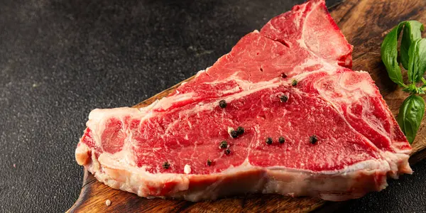 Çiğ biftek T-bone taze et prim biftek aperatif taze lezzetli gurme yemek arka planı masa rustik gıda üst görünüm fotokopi alanı