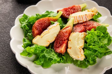 Salata inciri, yumuşak peynir, yeşil yaprak marul lezzetli aperatif lezzetli lezzetli gurme yemek arkaplan masa üzerinde rustik gıda üst görünüm fotokopi alanı keto ve paleo diyet vejetaryen gıda