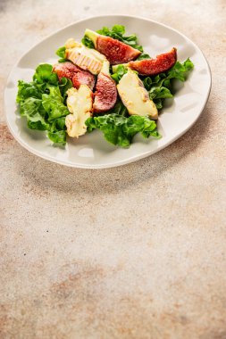 Salata inciri, yumuşak peynir, yeşil yaprak marul lezzetli aperatif lezzetli lezzetli gurme yemek arkaplan masa üzerinde rustik gıda üst görünüm fotokopi alanı keto ve paleo diyet vejetaryen gıda