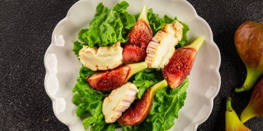 Salata inciri, yumuşak peynir, yeşil yaprak marul lezzetli aperatif lezzetli lezzetli gurme yemek arkaplan masa üzerinde rustik gıda üst görünüm fotokopi alanı keto ve paleo diyet vejetaryen gıda