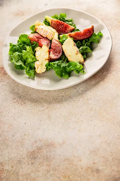 Salata inciri, yumuşak peynir, yeşil yaprak marul lezzetli aperatif lezzetli lezzetli gurme yemek arkaplan masa üzerinde rustik gıda üst görünüm fotokopi alanı keto ve paleo diyet vejetaryen gıda