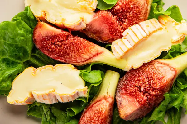 Salata inciri, yumuşak peynir, yeşil yaprak marul lezzetli aperatif lezzetli lezzetli gurme yemek arkaplan masa üzerinde rustik gıda üst görünüm fotokopi alanı keto ve paleo diyet vejetaryen gıda