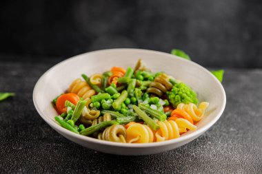 Trottole makarna sebzeler yeşil bezelye, yeşil fasulye, kohlrabi lahanası, brokoli ikinci yemek lezzetli çerez taze lezzetli gurme yemek arka planı masa kırsal gıda üst görünüm boşluk
