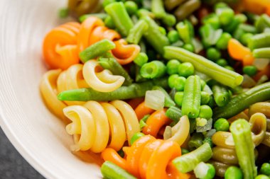 Trottole makarna sebzeler yeşil bezelye, yeşil fasulye, kohlrabi lahanası, brokoli ikinci yemek lezzetli çerez taze lezzetli gurme yemek arka planı masa kırsal gıda üst görünüm boşluk