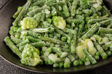 Donmuş yeşil sebzeler bezelye, brokoli, çalı fasulyesi, kohlrabi lahanası lezzetli çerez masadaki lezzetli gurme yemek arka planı rustik yemekler fotokopi alanı keto ve paleo diyeti vejetaryen ve vejetaryen yemekleri.