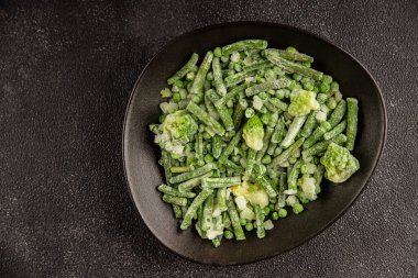 Donmuş yeşil sebzeler bezelye, brokoli, çalı fasulyesi, kohlrabi lahanası lezzetli çerez masadaki lezzetli gurme yemek arka planı rustik yemekler fotokopi alanı keto ve paleo diyeti vejetaryen ve vejetaryen yemekleri.