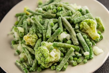 Donmuş yeşil sebzeler bezelye, brokoli, çalı fasulyesi, kohlrabi lahanası lezzetli çerez masadaki lezzetli gurme yemek arka planı rustik yemekler fotokopi alanı keto ve paleo diyeti vejetaryen ve vejetaryen yemekleri.