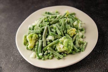 Donmuş yeşil sebzeler bezelye, brokoli, çalı fasulyesi, kohlrabi lahanası lezzetli çerez masadaki lezzetli gurme yemek arka planı rustik yemekler fotokopi alanı keto ve paleo diyeti vejetaryen ve vejetaryen yemekleri.