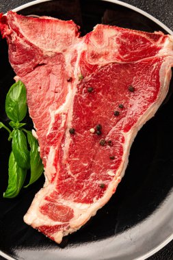 Çiğ biftek T-bone taze et prim biftek aperatif taze lezzetli gurme yemek arka planı masa rustik gıda üst görünüm fotokopi alanı