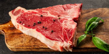 Çiğ biftek T-bone taze et prim biftek aperatif taze lezzetli gurme yemek arka planı masa rustik gıda üst görünüm fotokopi alanı