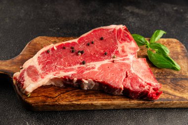 Çiğ biftek T-bone taze et prim biftek aperatif taze lezzetli gurme yemek arka planı masa rustik gıda üst görünüm fotokopi alanı