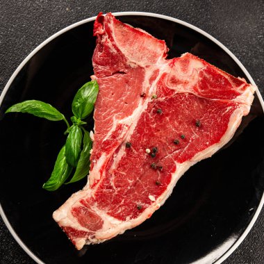 Çiğ biftek T-bone taze et prim biftek aperatif taze lezzetli gurme yemek arka planı masa rustik gıda üst görünüm fotokopi alanı