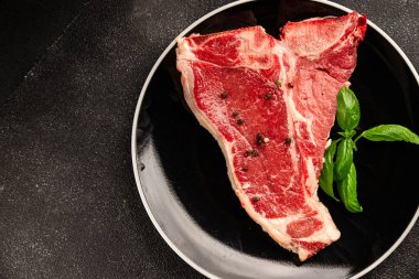 Çiğ biftek T-bone taze et prim biftek aperatif taze lezzetli gurme yemek arka planı masa rustik gıda üst görünüm fotokopi alanı