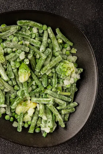 Donmuş yeşil sebzeler bezelye, brokoli, çalı fasulyesi, kohlrabi lahanası lezzetli çerez masadaki lezzetli gurme yemek arka planı rustik yemekler fotokopi alanı keto ve paleo diyeti vejetaryen ve vejetaryen yemekleri.