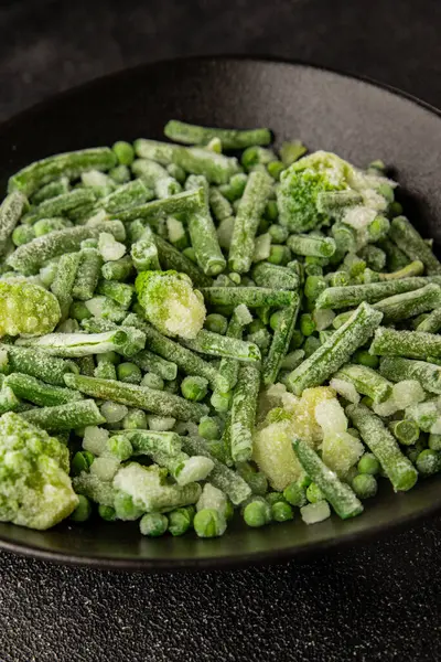 Donmuş yeşil sebzeler bezelye, brokoli, çalı fasulyesi, kohlrabi lahanası lezzetli çerez masadaki lezzetli gurme yemek arka planı rustik yemekler fotokopi alanı keto ve paleo diyeti vejetaryen ve vejetaryen yemekleri.