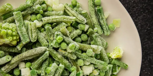 Donmuş yeşil sebzeler bezelye, brokoli, çalı fasulyesi, kohlrabi lahanası lezzetli çerez masadaki lezzetli gurme yemek arka planı rustik yemekler fotokopi alanı keto ve paleo diyeti vejetaryen ve vejetaryen yemekleri.