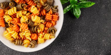 makarna trottole üç renkli makarna sarmalı bükülmüş İtalyan yemeği lezzetli çerez lezzetli gurme yemek arkaplan masa üzerinde rustik üst görünüm fotokopi alanı vegan ve vejetaryen gıda