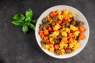 makarna trottole üç renkli makarna sarmalı bükülmüş İtalyan yemeği lezzetli çerez lezzetli gurme yemek arkaplan masa üzerinde rustik üst görünüm fotokopi alanı vegan ve vejetaryen gıda