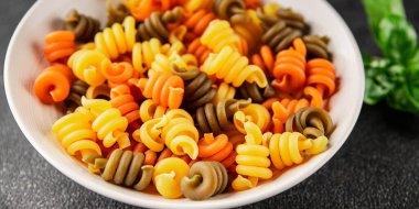 makarna trottole üç renkli makarna sarmalı bükülmüş İtalyan yemeği lezzetli çerez lezzetli gurme yemek arkaplan masa üzerinde rustik üst görünüm fotokopi alanı vegan ve vejetaryen gıda