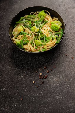 Spagetti sebzesi, bezelye, brokoli, çalı fasulyesi, kohlrabi vejetaryen makarna lezzetli makarna masanın üzerinde taze lezzetli gurme yemek.