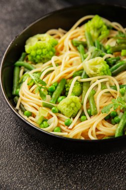 Spagetti sebzesi, bezelye, brokoli, çalı fasulyesi, kohlrabi vejetaryen makarna lezzetli makarna masanın üzerinde taze lezzetli gurme yemek.