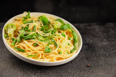 Spagetti sebzesi, bezelye, brokoli, çalı fasulyesi, kohlrabi vejetaryen makarna lezzetli makarna masanın üzerinde taze lezzetli gurme yemek.