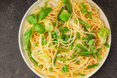 Spagetti sebzesi, bezelye, brokoli, çalı fasulyesi, kohlrabi vejetaryen makarna lezzetli makarna masanın üzerinde taze lezzetli gurme yemek.