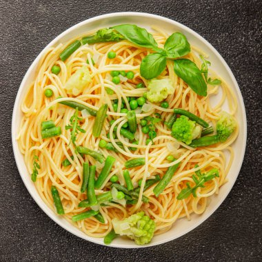 Spagetti sebzesi, bezelye, brokoli, çalı fasulyesi, kohlrabi vejetaryen makarna lezzetli makarna masanın üzerinde taze lezzetli gurme yemek.