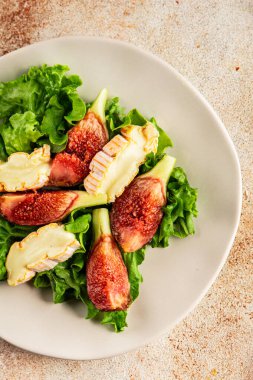 Salata inciri, yumuşak peynir, yeşil yaprak marul lezzetli aperatif lezzetli lezzetli gurme yemek arkaplan masa üzerinde rustik gıda üst görünüm fotokopi alanı keto ve paleo diyet vejetaryen gıda