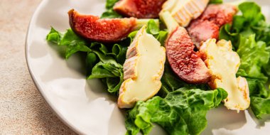 Salata inciri, yumuşak peynir, yeşil yaprak marul lezzetli aperatif lezzetli lezzetli gurme yemek arkaplan masa üzerinde rustik gıda üst görünüm fotokopi alanı keto ve paleo diyet vejetaryen gıda