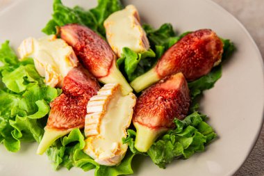 Salata inciri, yumuşak peynir, yeşil yaprak marul lezzetli aperatif lezzetli lezzetli gurme yemek arkaplan masa üzerinde rustik gıda üst görünüm fotokopi alanı keto ve paleo diyet vejetaryen gıda